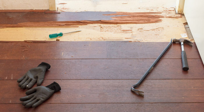 damaged wooden floor with tools laying on it